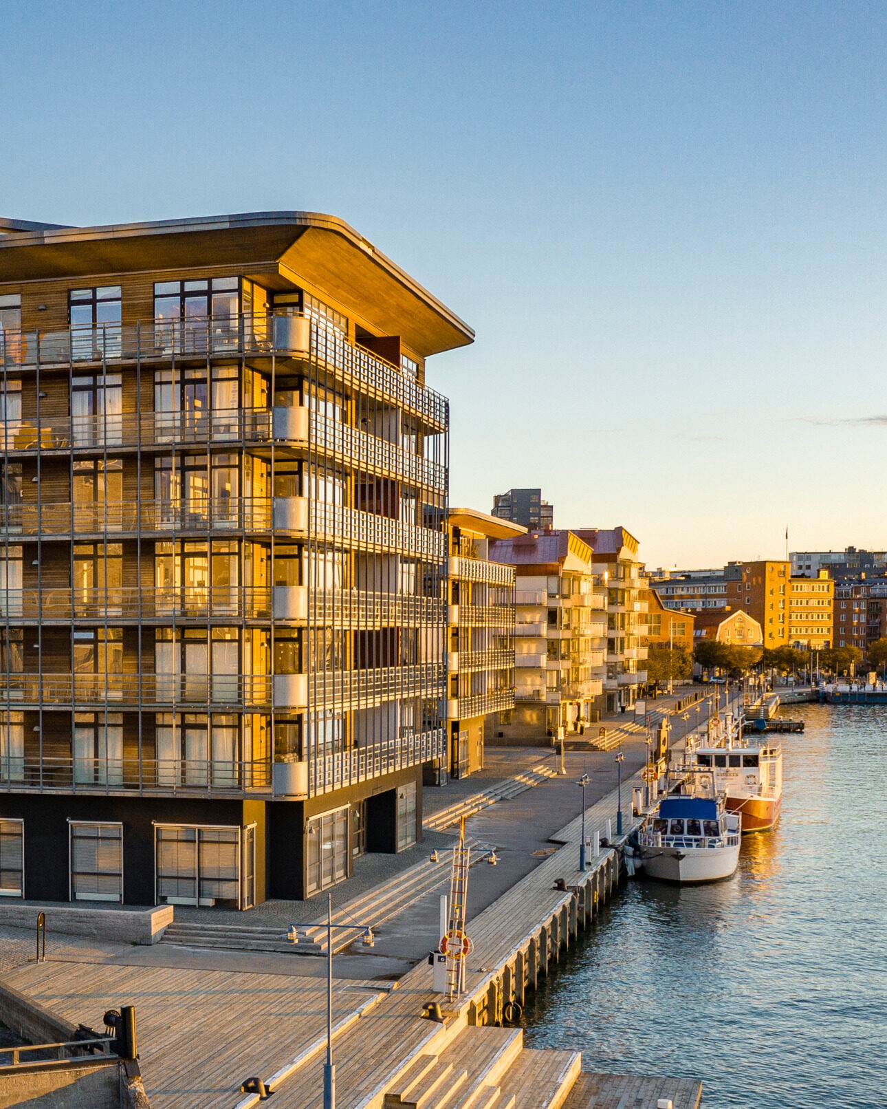 Modern waterfront buildings at sunset in a Swedish coastal city