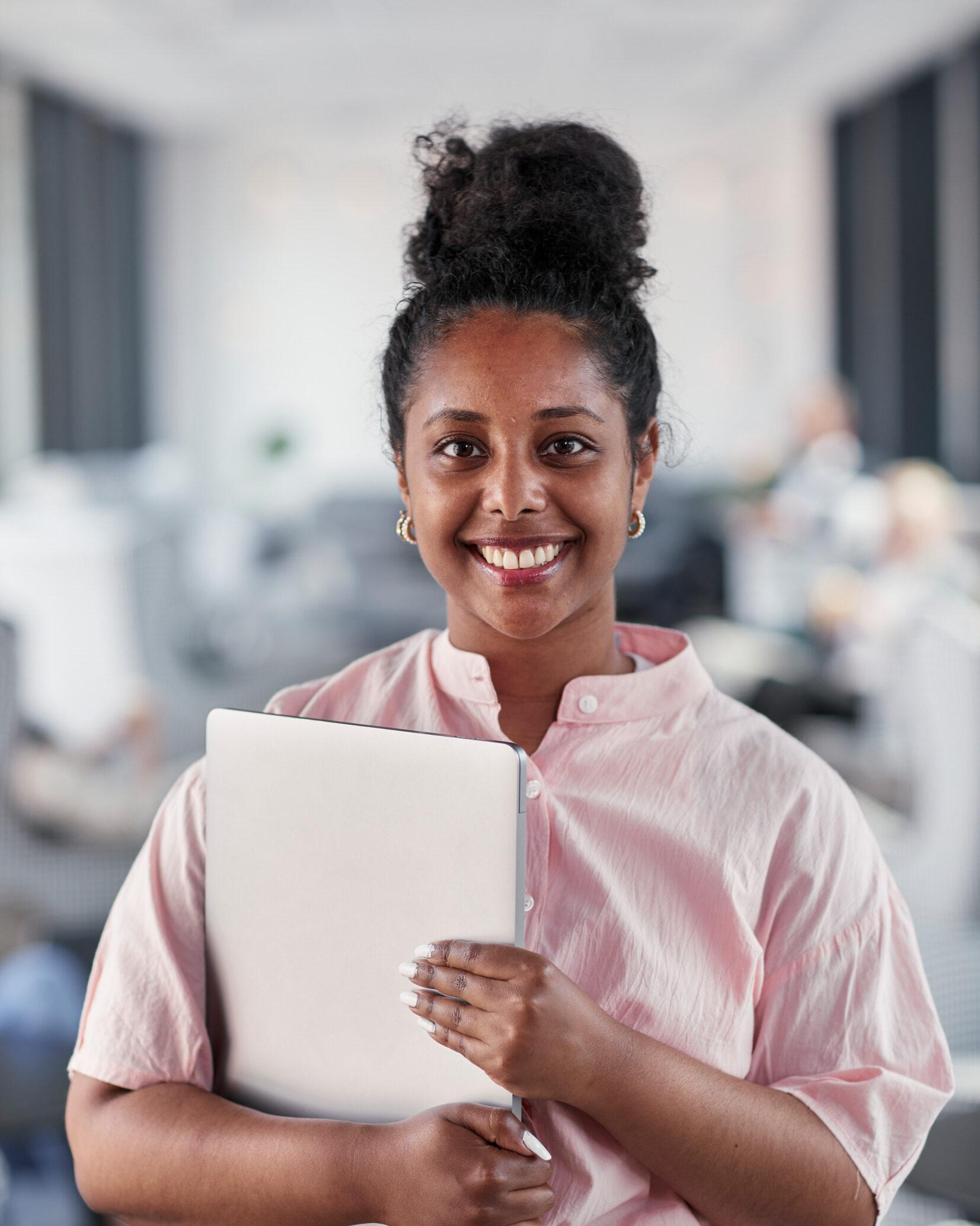 Woman smiling holding a laptop