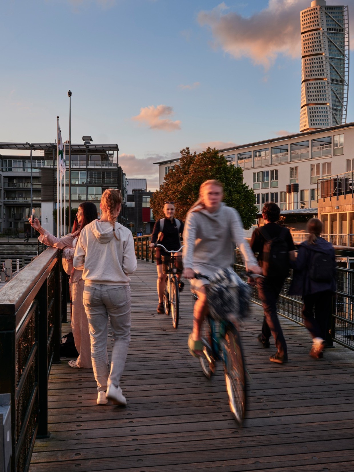 People biking over a bridge in a city